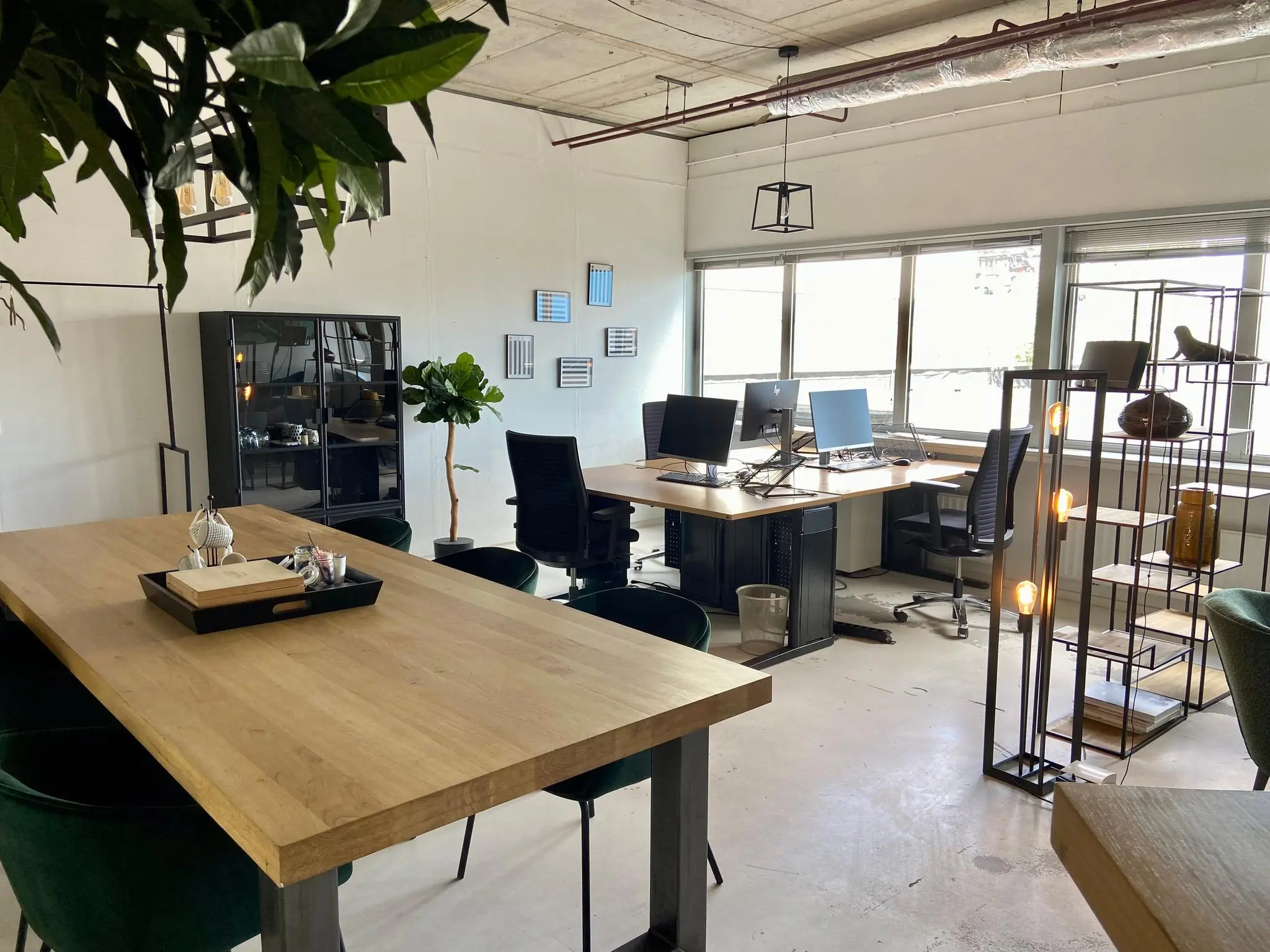 Modern ingericht kantoor aan de Anthony Fokkerweg met houten bureaus, groene stoelen en veel natuurlijk licht.